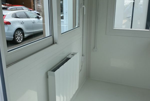 internal view of a white kiosk with a wall heater and sliding window